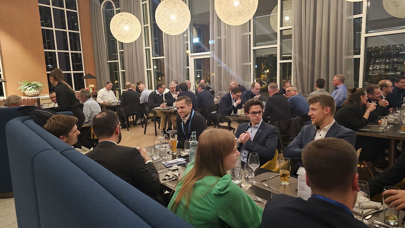 Foto von den Teilnehmern auf der Abendveranstaltung des Fachkongress Fabrikplanung 2025 während sie an den Tischen sitzen und sich austauschen