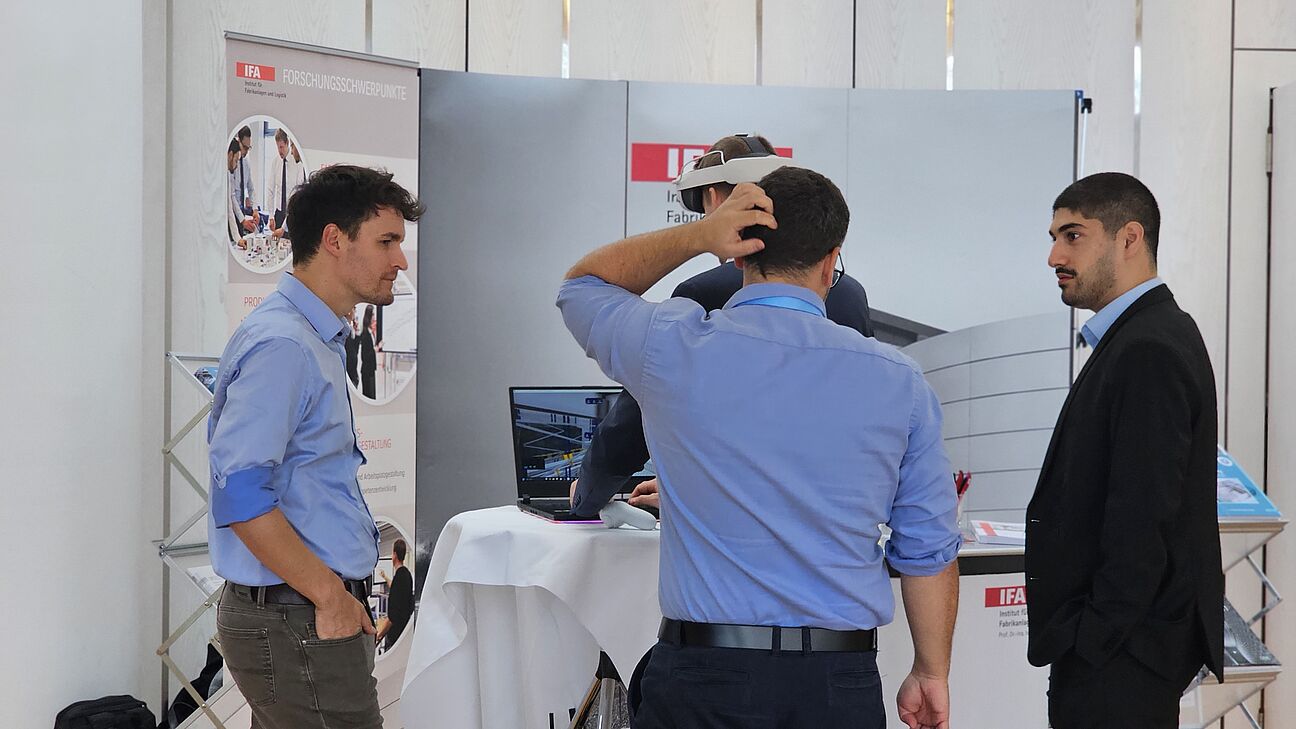 Vier Teilnehmer im Ausstellerbereich des Deutschen Fachkongress Fabrikplanung am Stand von IFA