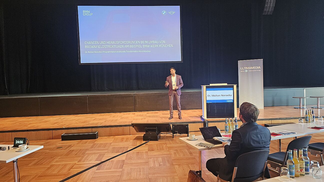 Dr. Mohan Noronha während seines Vortrags auf der Bühne beim Fachkongress Fabrikplanung 2025