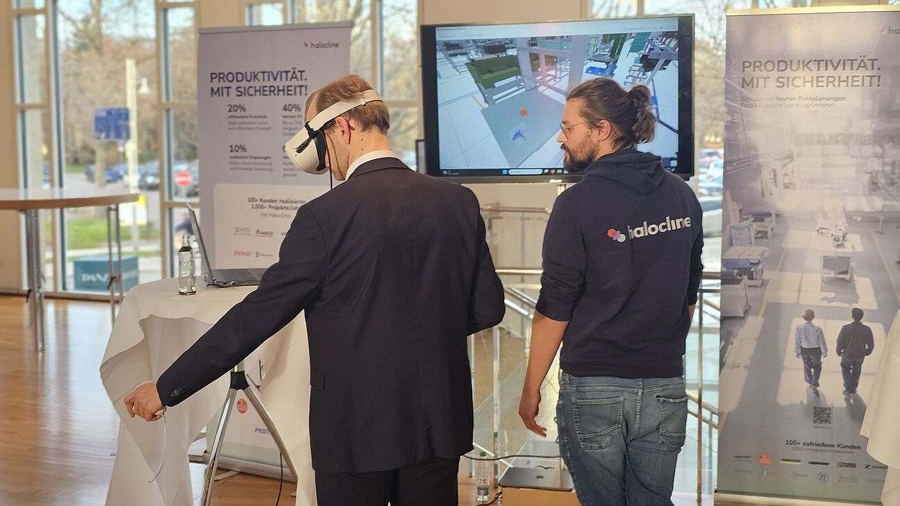 Teilnehmer testet am Stand von halocline auf dem Deutschen Fachkongress Fabrikplanung eine VR-Brille.  