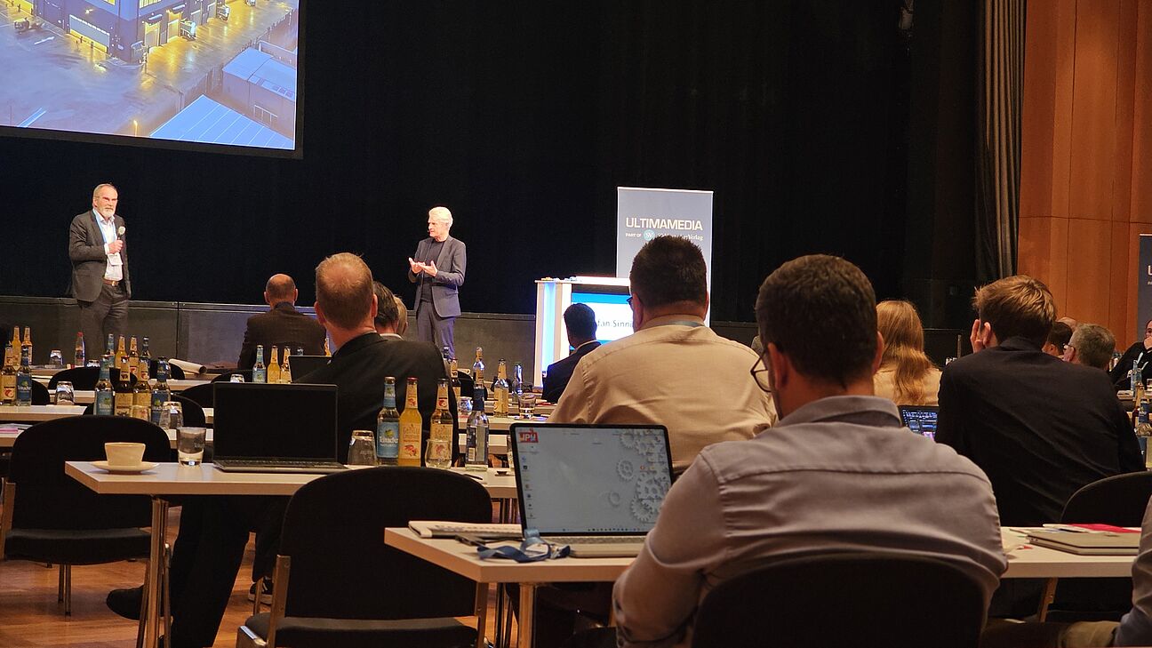Dr. Jürgen Bischoff und Stefan Sinning auf der Bühne des Fachkongress Fabrikplanung 2025
