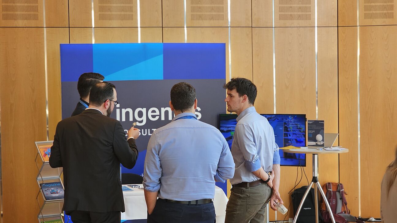 Vier Teilnehmer am Stand von ingenics am Austausch auf dem Fachkongress Fabrikplanung 2025