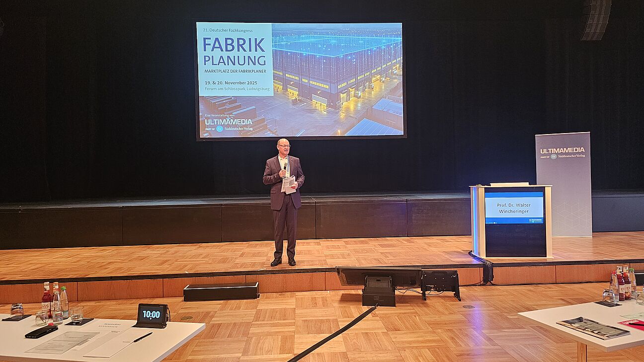 Prof. Dr. Walter Wicheringer spricht auf der Bühne beim Deutschen Fachkongress Fabrikplanung 2025 in Ludwigsburg 