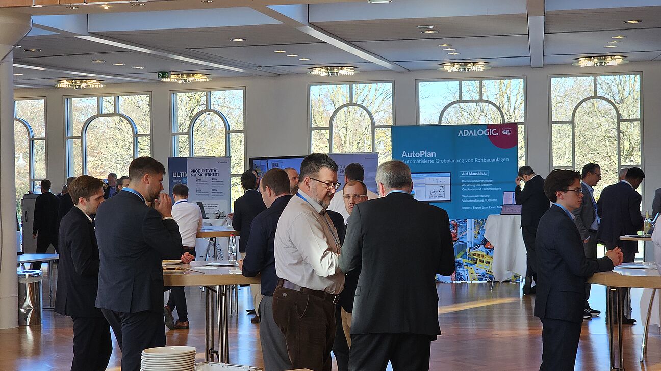 Ausstellerbereich des Deutschen Fachkongress Fabrikplanung 2025 in Ludwigsburg. Man sieht viele Teilnehmer während der Kaffeepause am Netzwerken. 