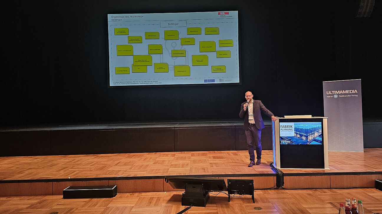 Prof. Dr. Matthias Schmidt während seines Vortrags auf der Bühne beim Deutschen Fachkongress Fabrikplanung 2025