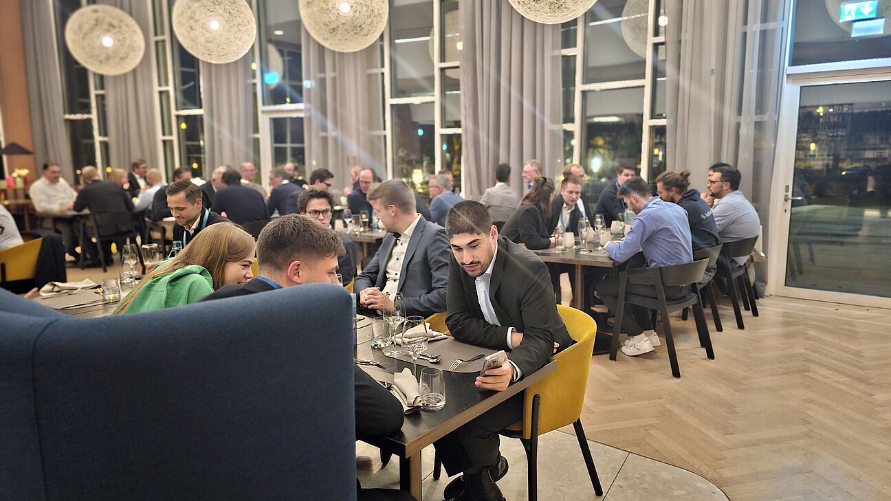 Foto von den Teilnehmern auf der Abendveranstaltung des Fachkongress Fabrikplanung 2025 während sie an den Tischen sitzen und sich austauschen