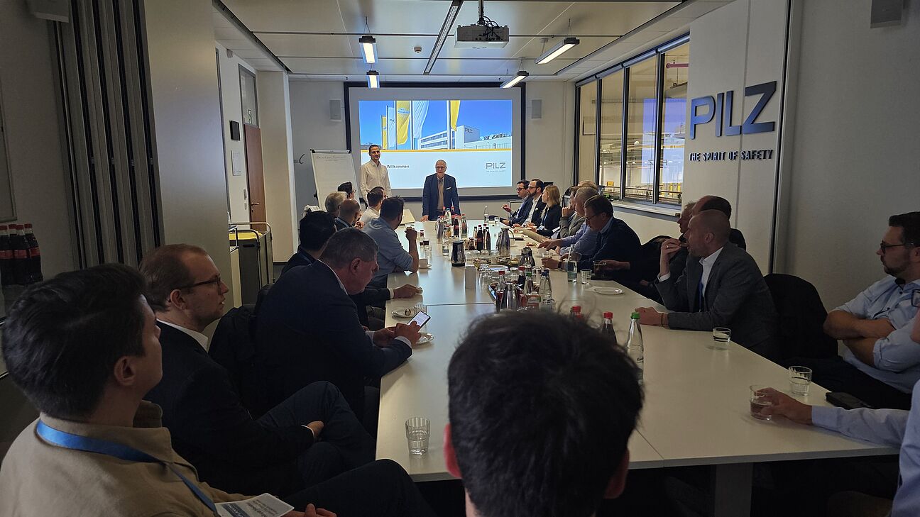 Werksführung bei PILZ GmbH. Teilnehmer des Deutschen Fachkongress Fabrikplanung sitzen im Vortragsraum bei Pilz GmbH